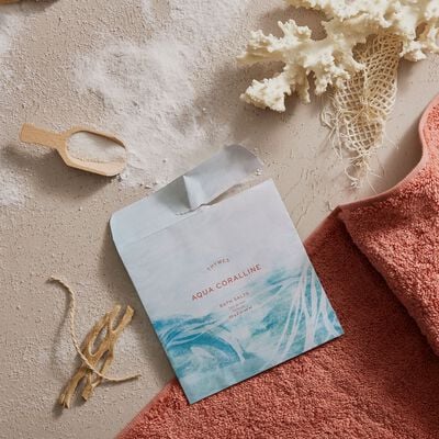 Thymes Neroli Sol Bath Salts Envelope for an Island Spa Experience flat lay with sand and shells